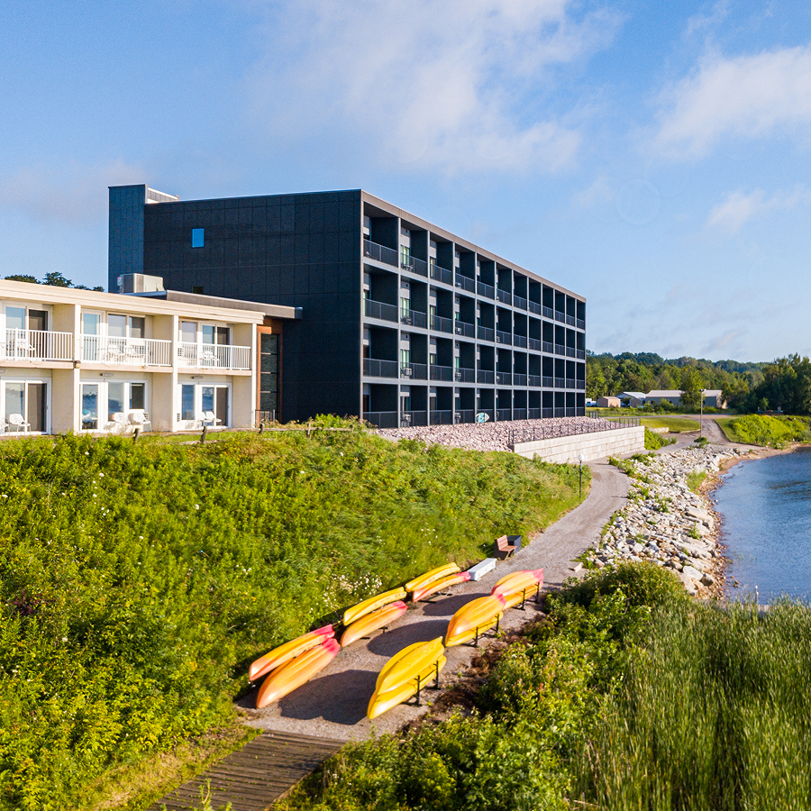 a building with a body of water and a row of canoes