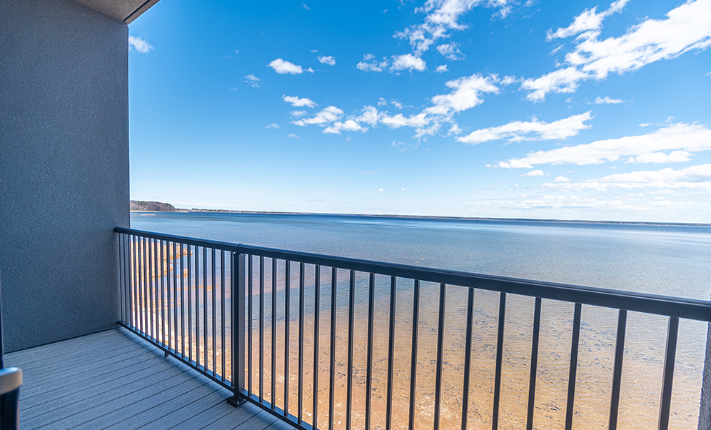 a deck with a railing overlooking a body of water