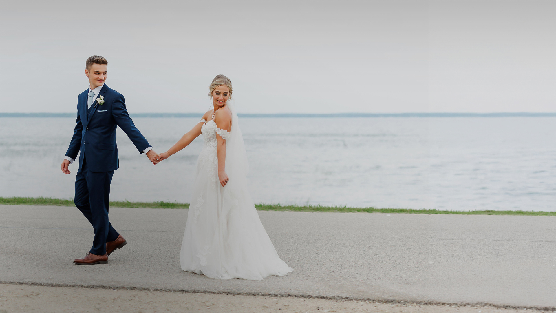 a man and woman holding hands and walking on a sidewalk