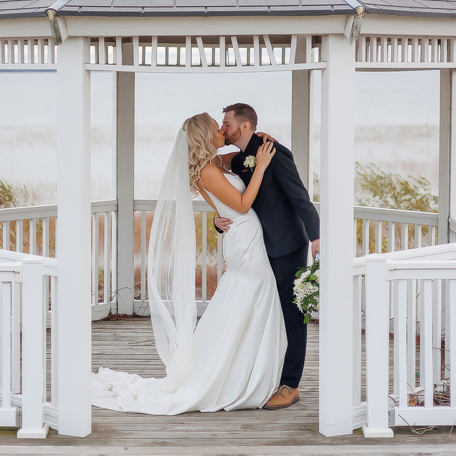 a man and woman kissing under a gazebo