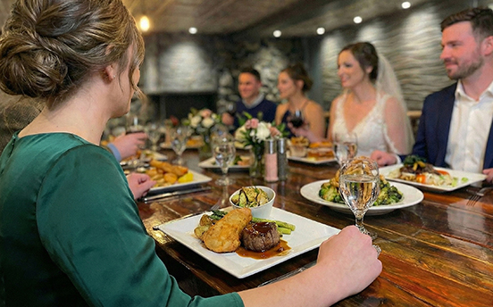 a group of people sitting at a table with food