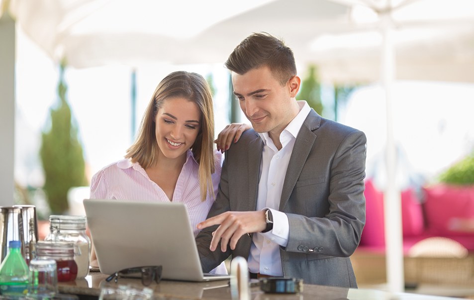 a man and woman looking at a laptop