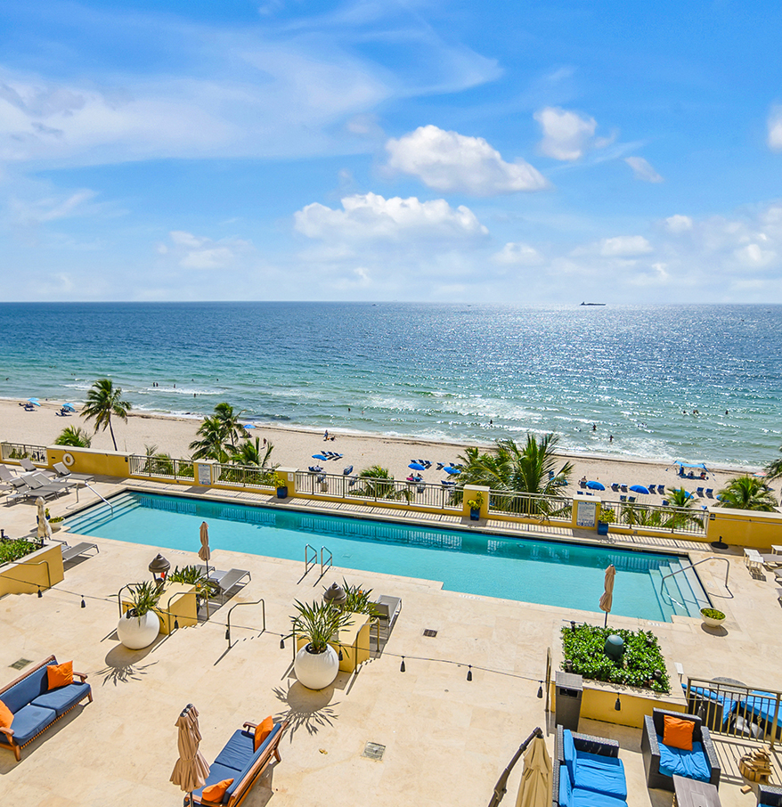 a swimming pool and chairs on a beach