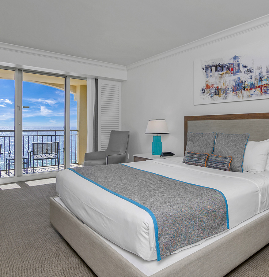 a bedroom with a large bed and a glass door