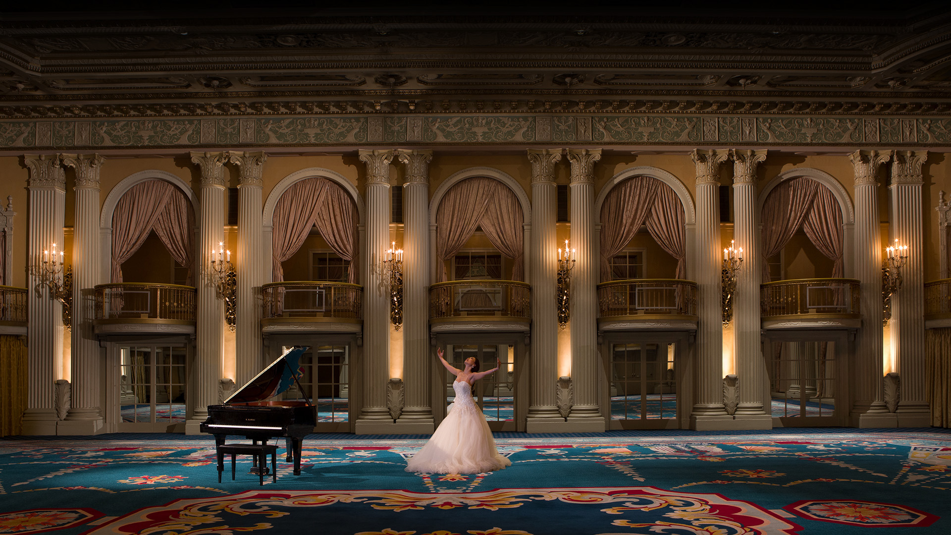 a woman in a white dress in front of a grand piano