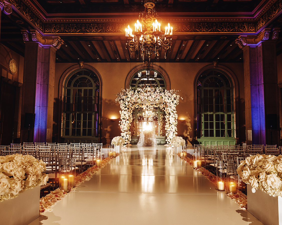 a wedding aisle with flowers and candles