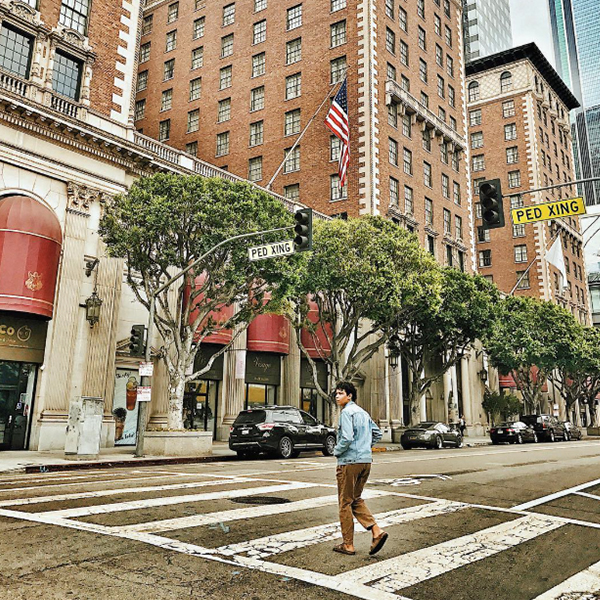 a man walking on a crosswalk in a city