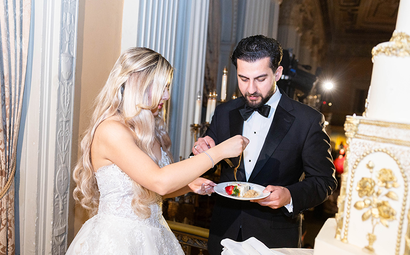a man in a tuxedo feeding a woman with food