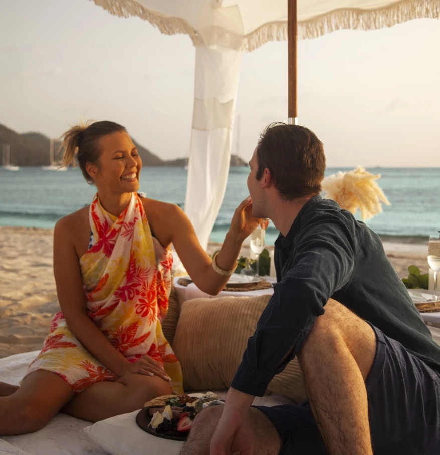 a man and woman sitting on a beach