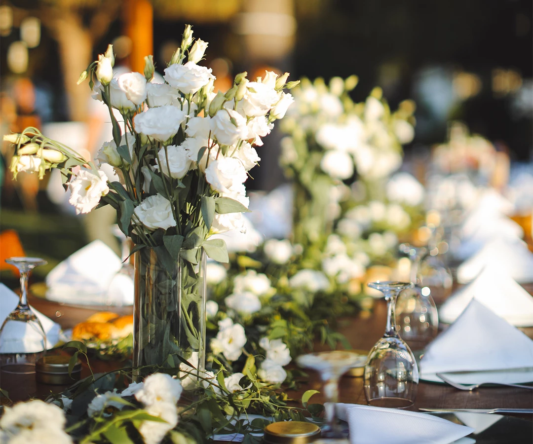 a table with white flowers and glasses