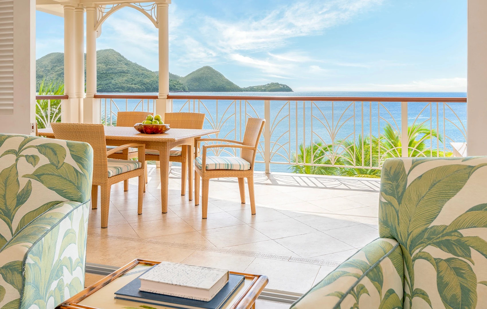 a patio with a table and chairs and a view of the ocean