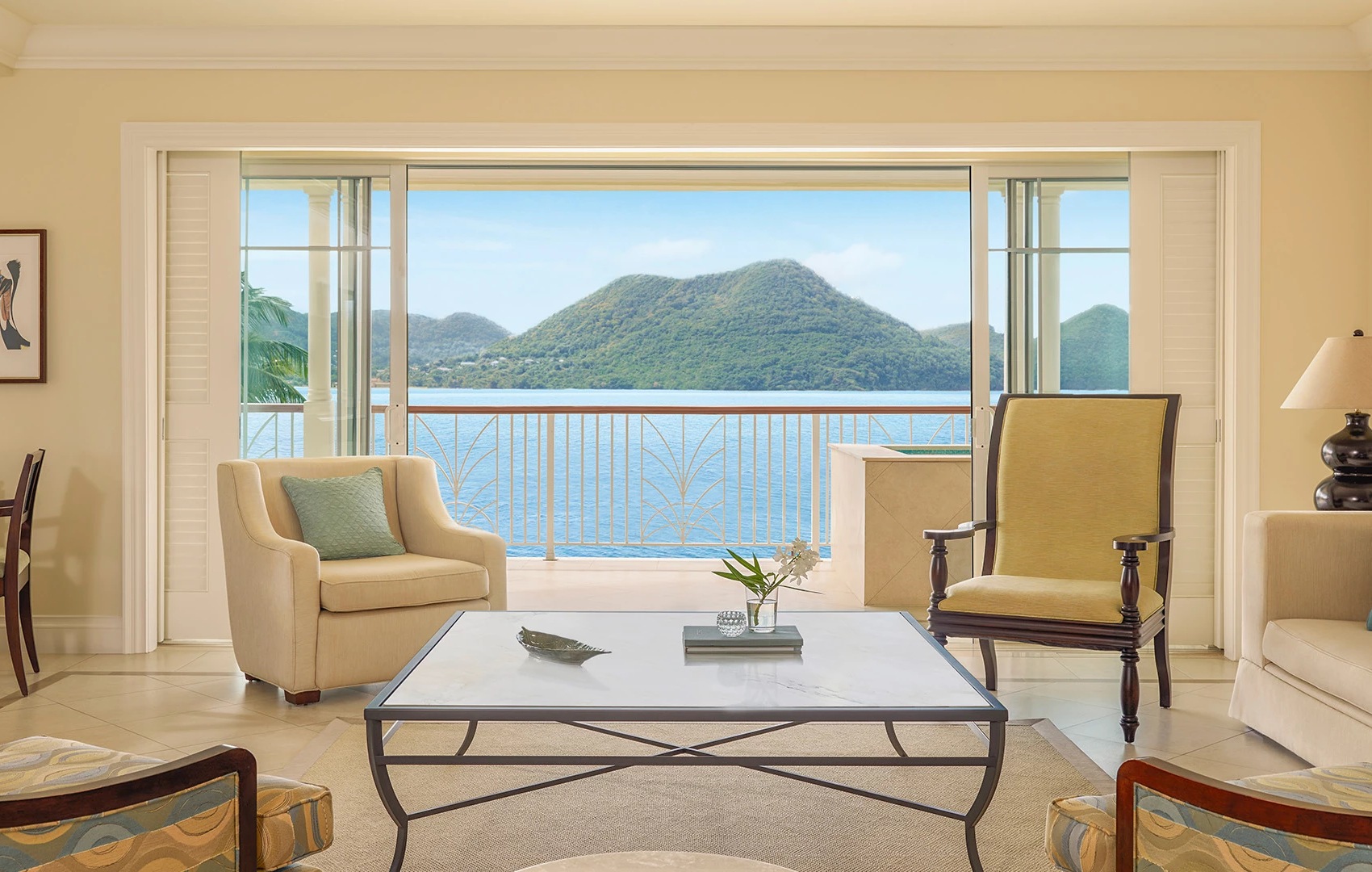 a living room with a view of the ocean and mountains