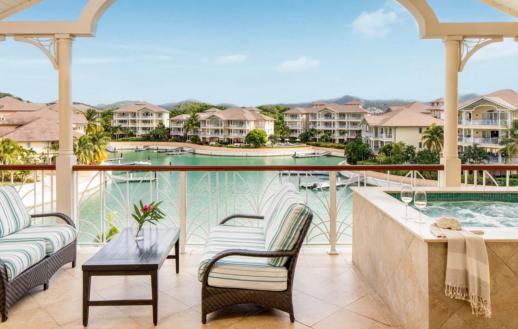 a chair and table on a balcony overlooking a body of water