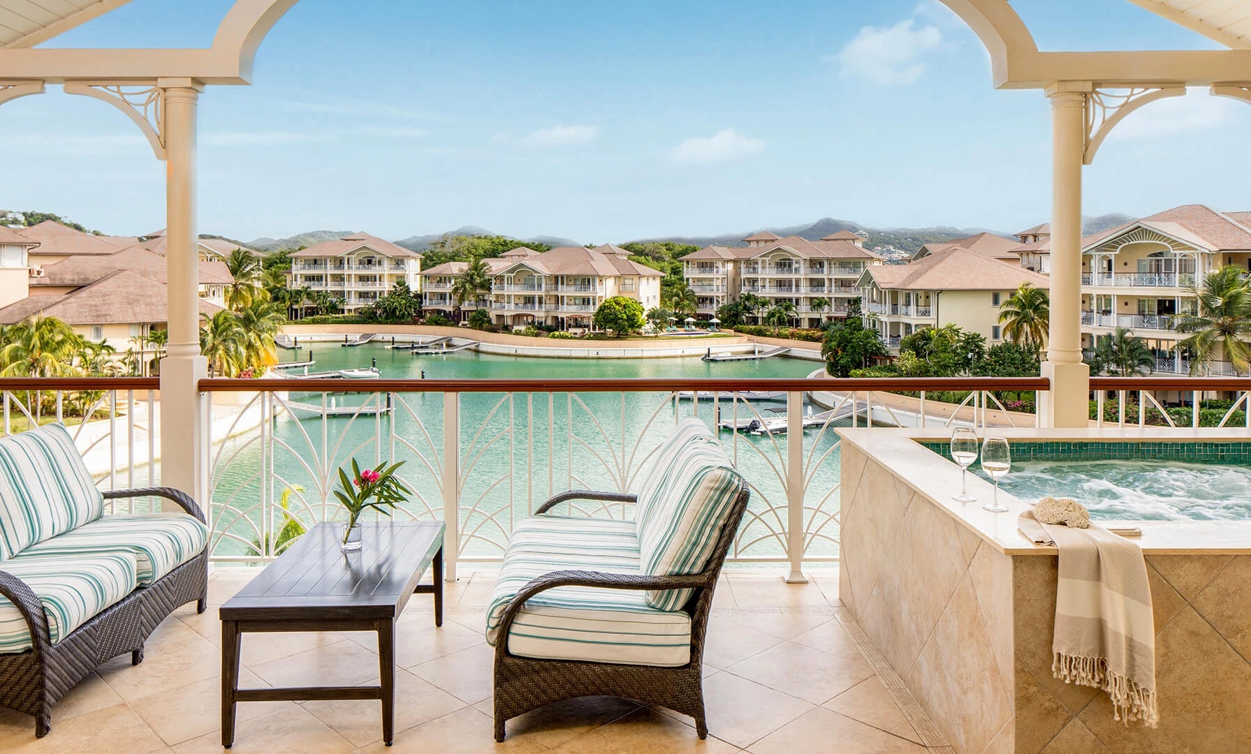 a chair and table on a balcony overlooking a body of water
