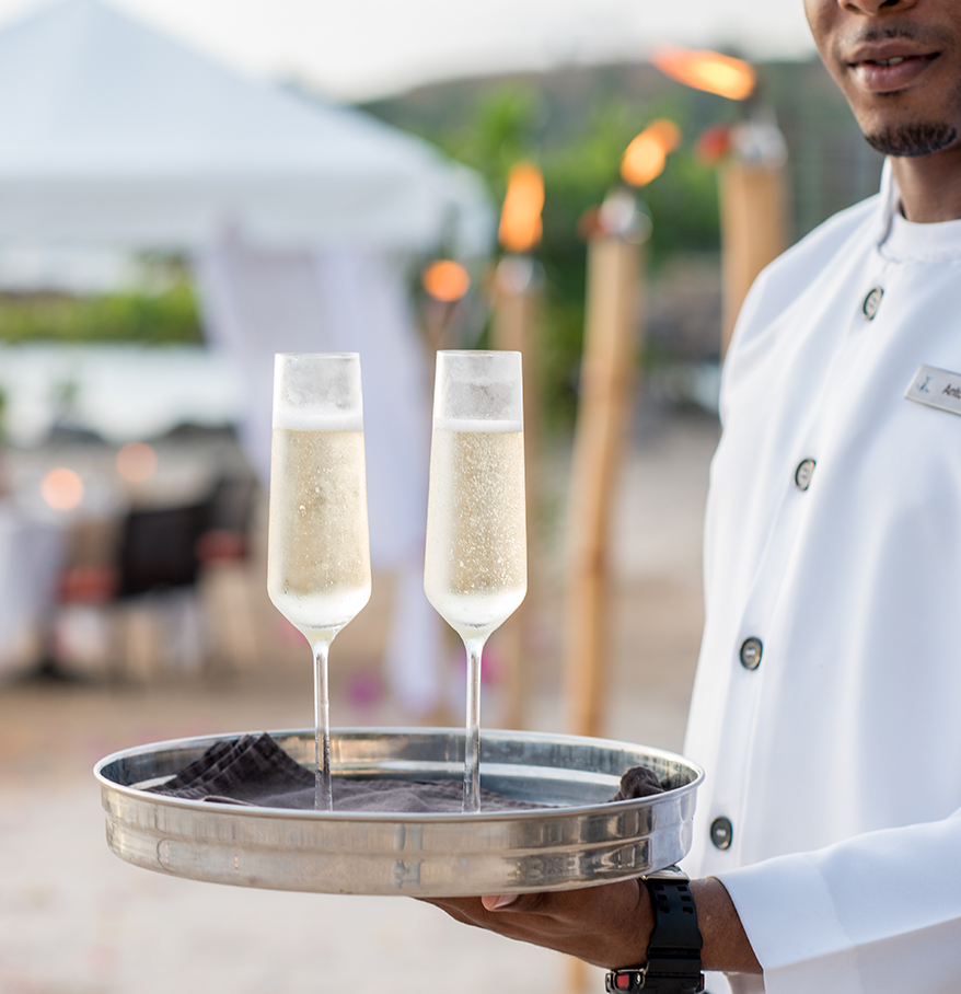 a man holding a tray with champagne glasses