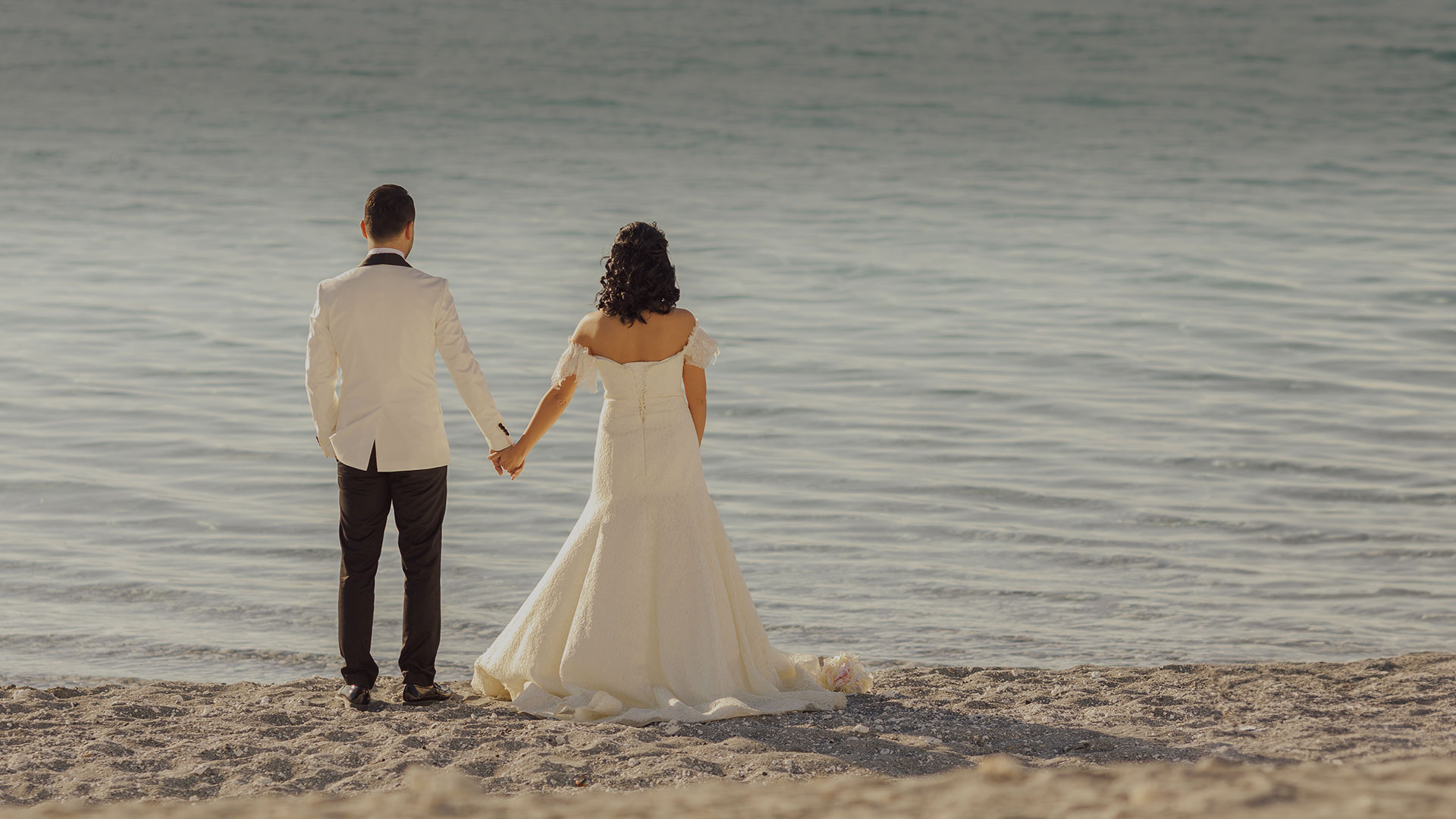 a man and woman holding hands on a beach