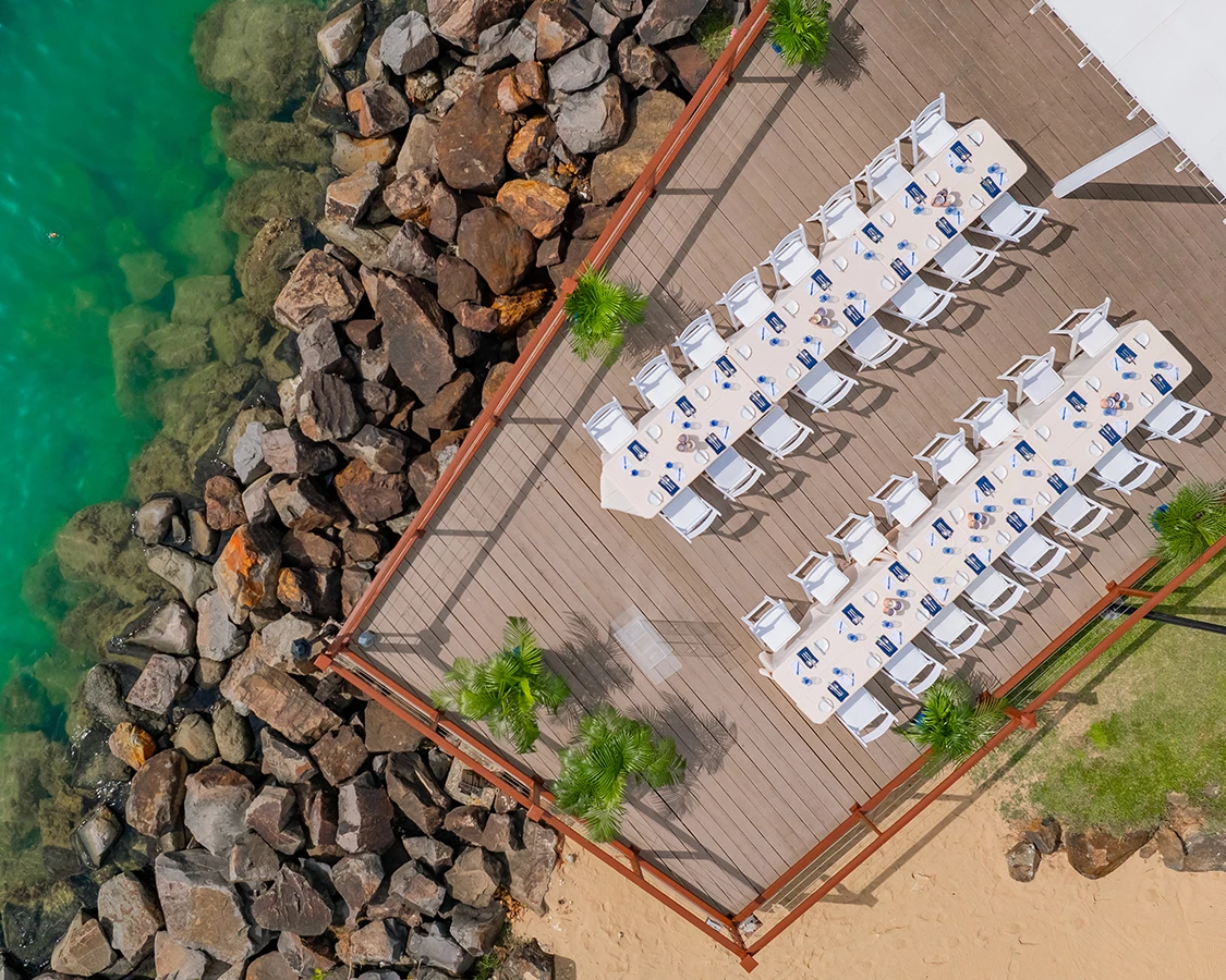 a group of chairs on a dock next to a body of water
