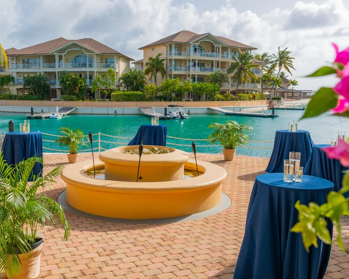 a pool with tables and chairs and a building in the background