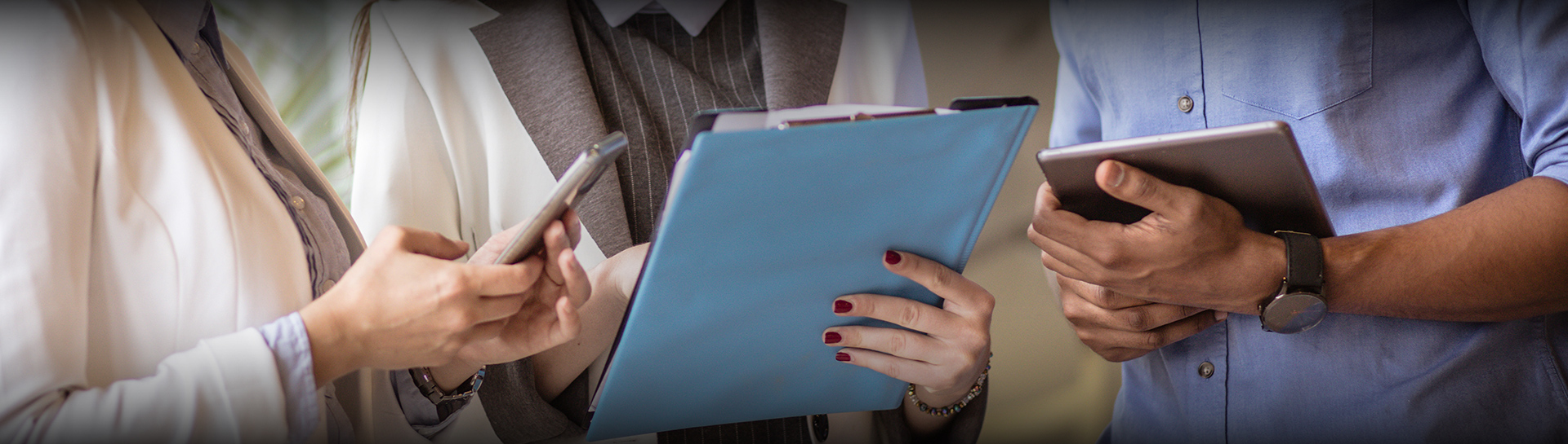 a woman holding a blue folder and a cell phone
