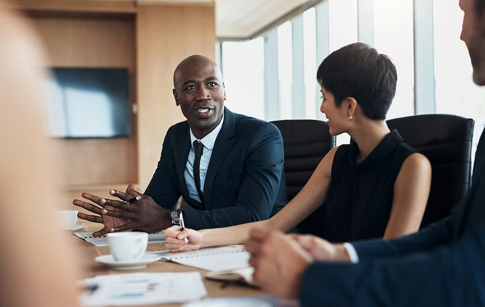 a group of people sitting around a table talking