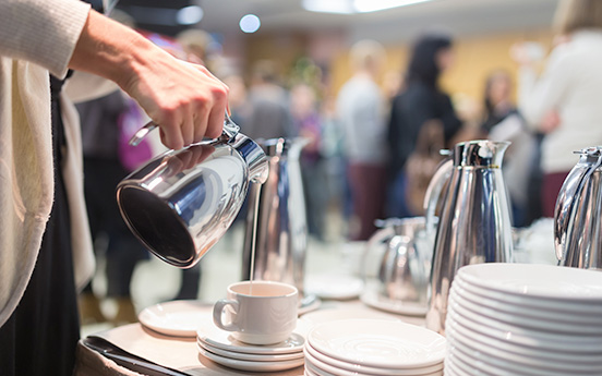 a person pouring milk into a cup