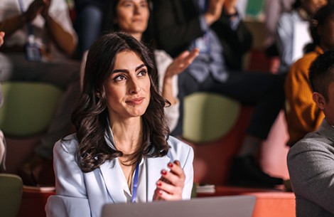 a woman sitting at a table with her hands together