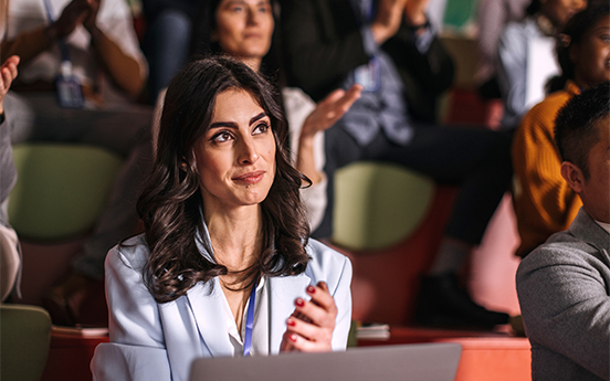 a woman sitting at a table with her hands together