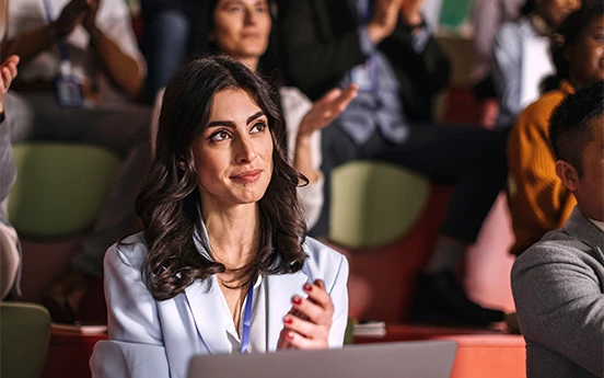 a woman sitting at a table with her hands together