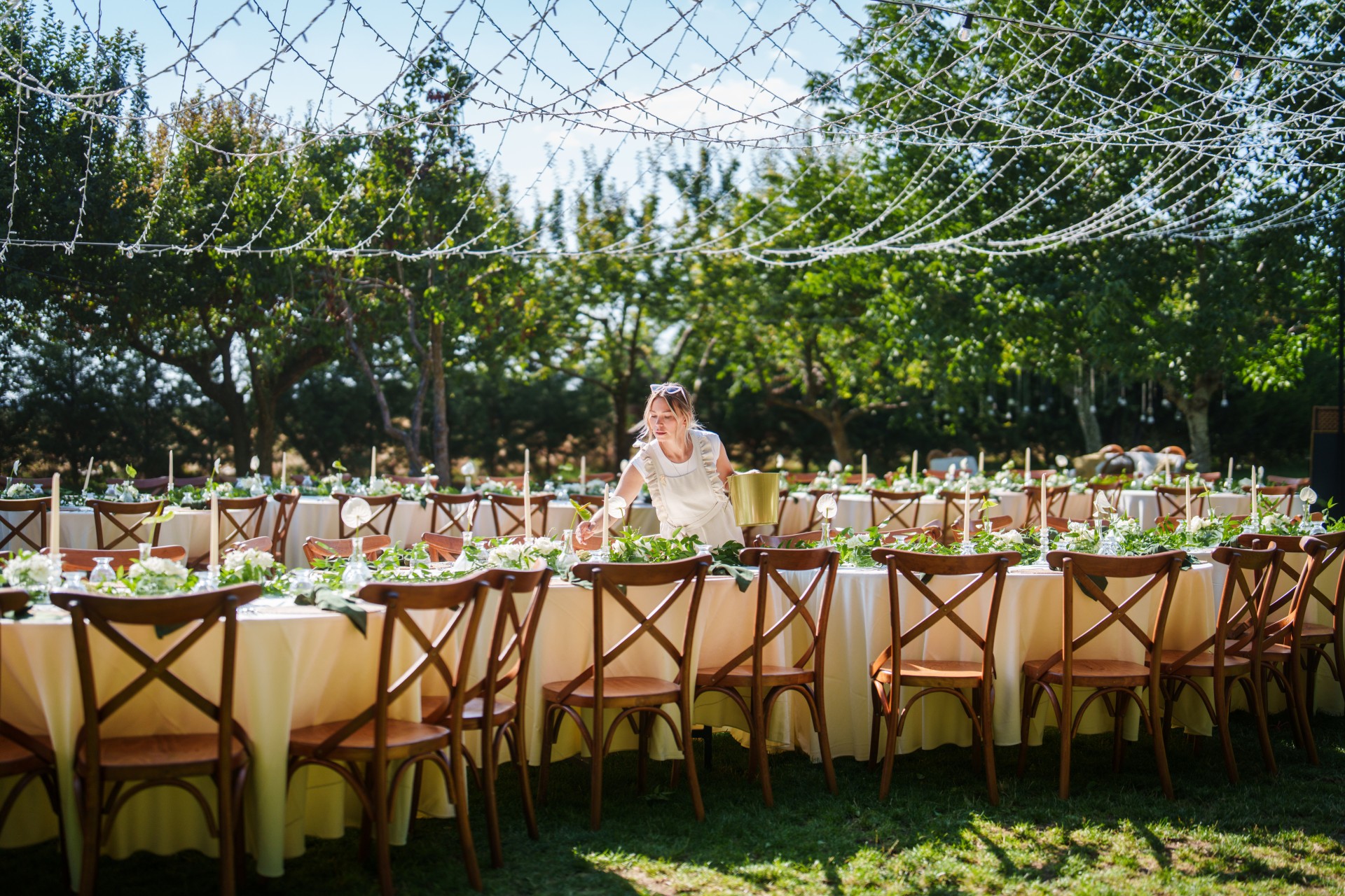 a woman standing at a table with tables and chairs