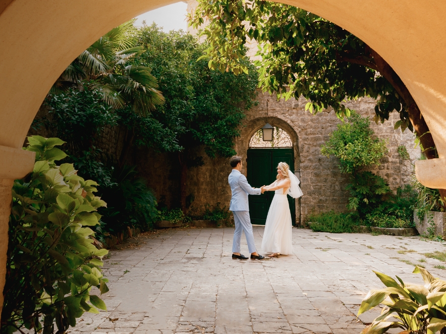 a man and woman holding hands in a courtyard