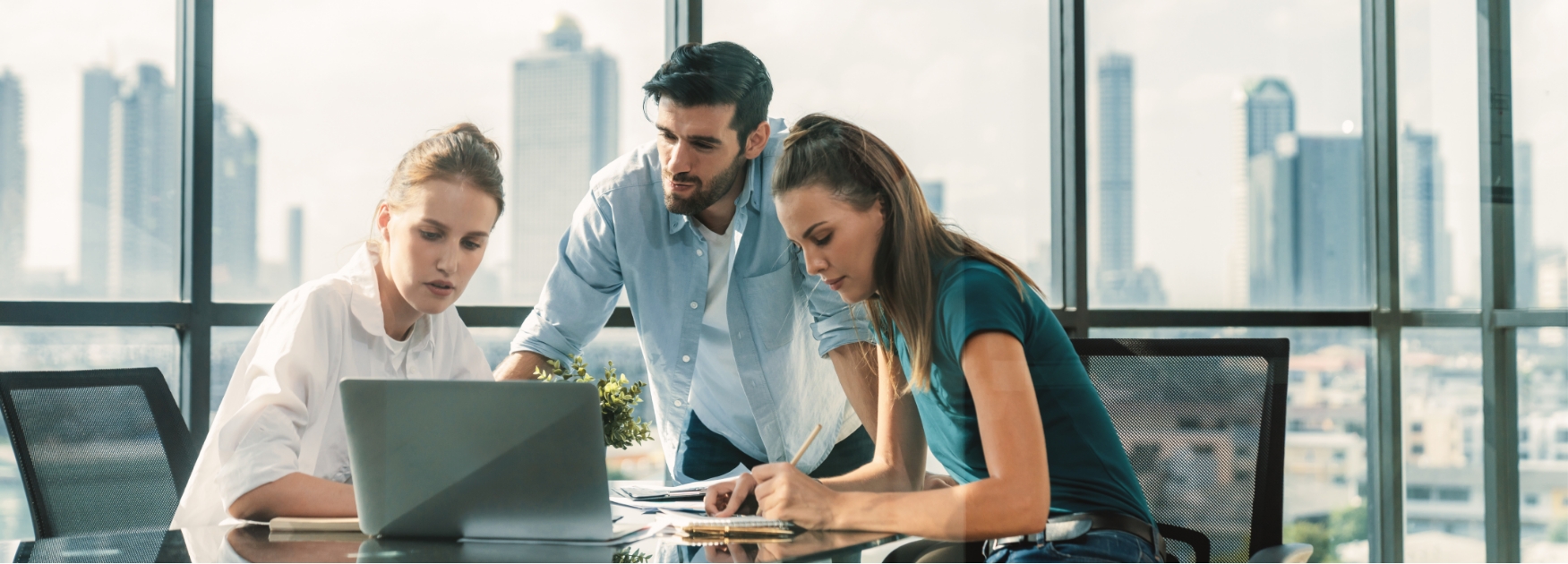 a group of people looking at a laptop