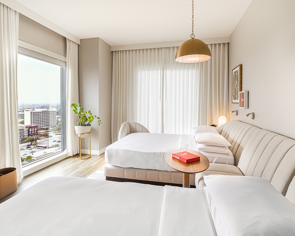 a room with two beds and a table with a window