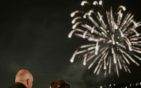 a man and woman looking at fireworks