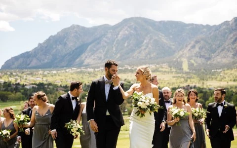 a man in a suit and a woman in a white dress holding flowers
