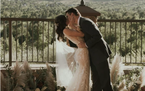 a man and woman kissing on a balcony