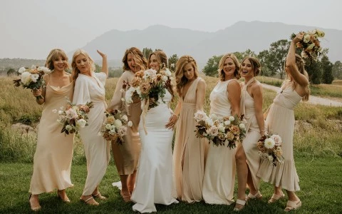 a group of women in white dresses posing for a photo