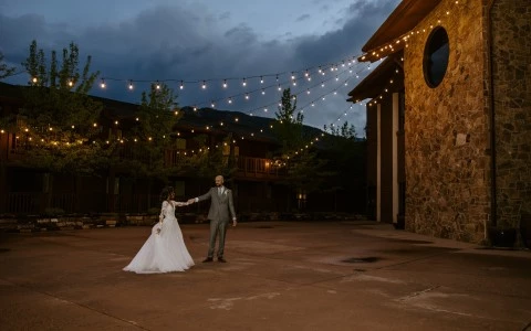 a bride and groom holding hands in front of a building