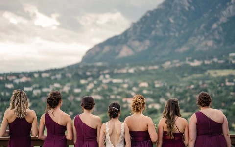 a group of women in dresses looking at a mountain