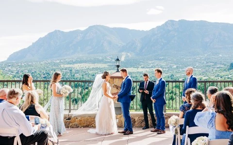 a group of people standing on a balcony with a mountain in the background