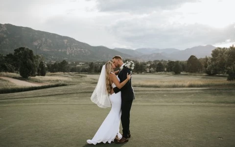 a man and woman kissing on a golf course