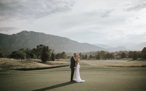 a man and woman standing on a golf course