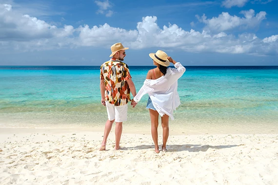 a man and woman holding hands on a beach