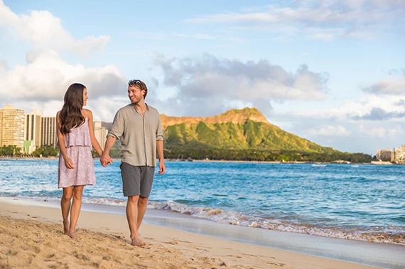a man and woman holding hands on a beach