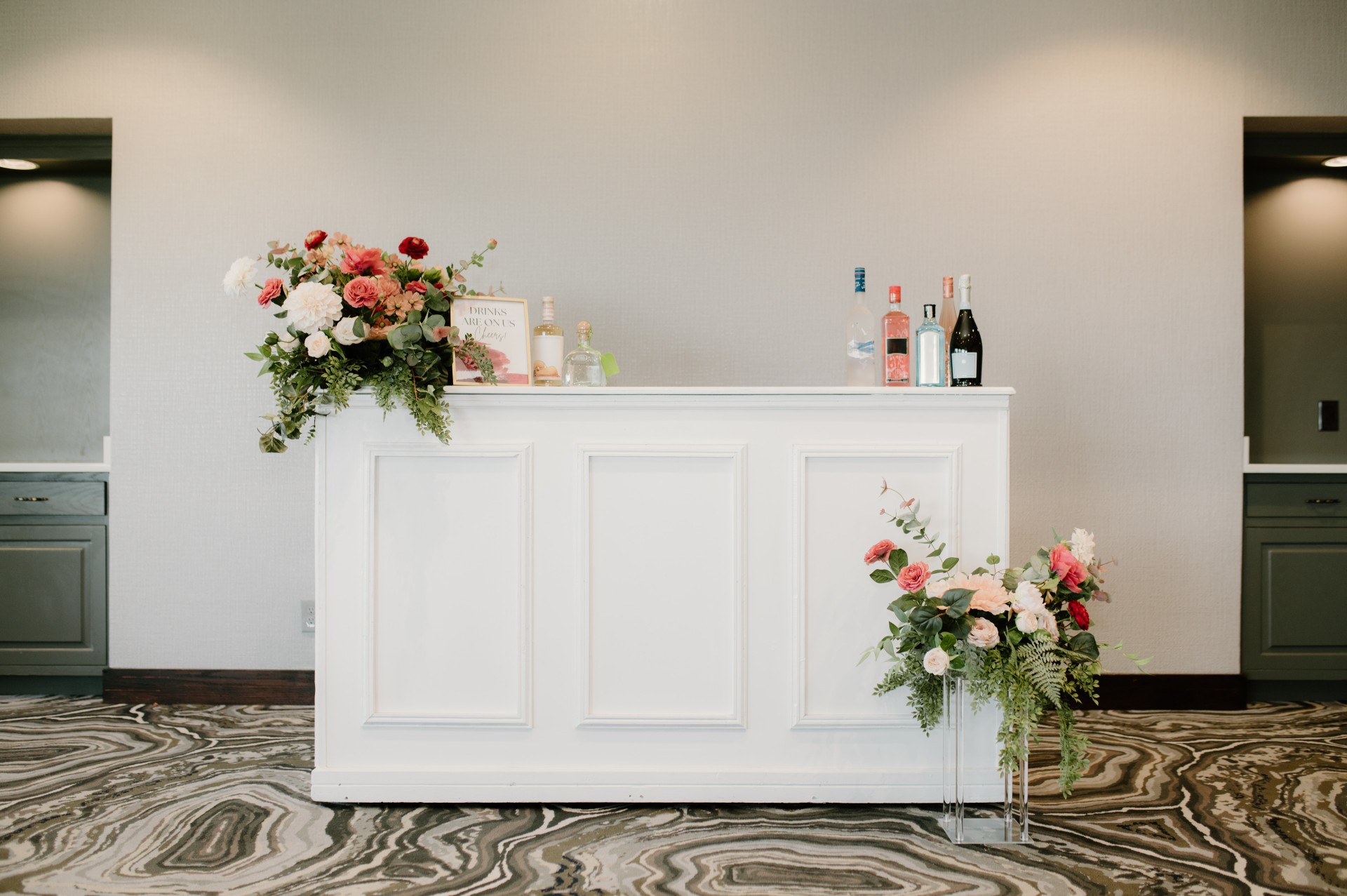 a white bar with flowers and bottles on top