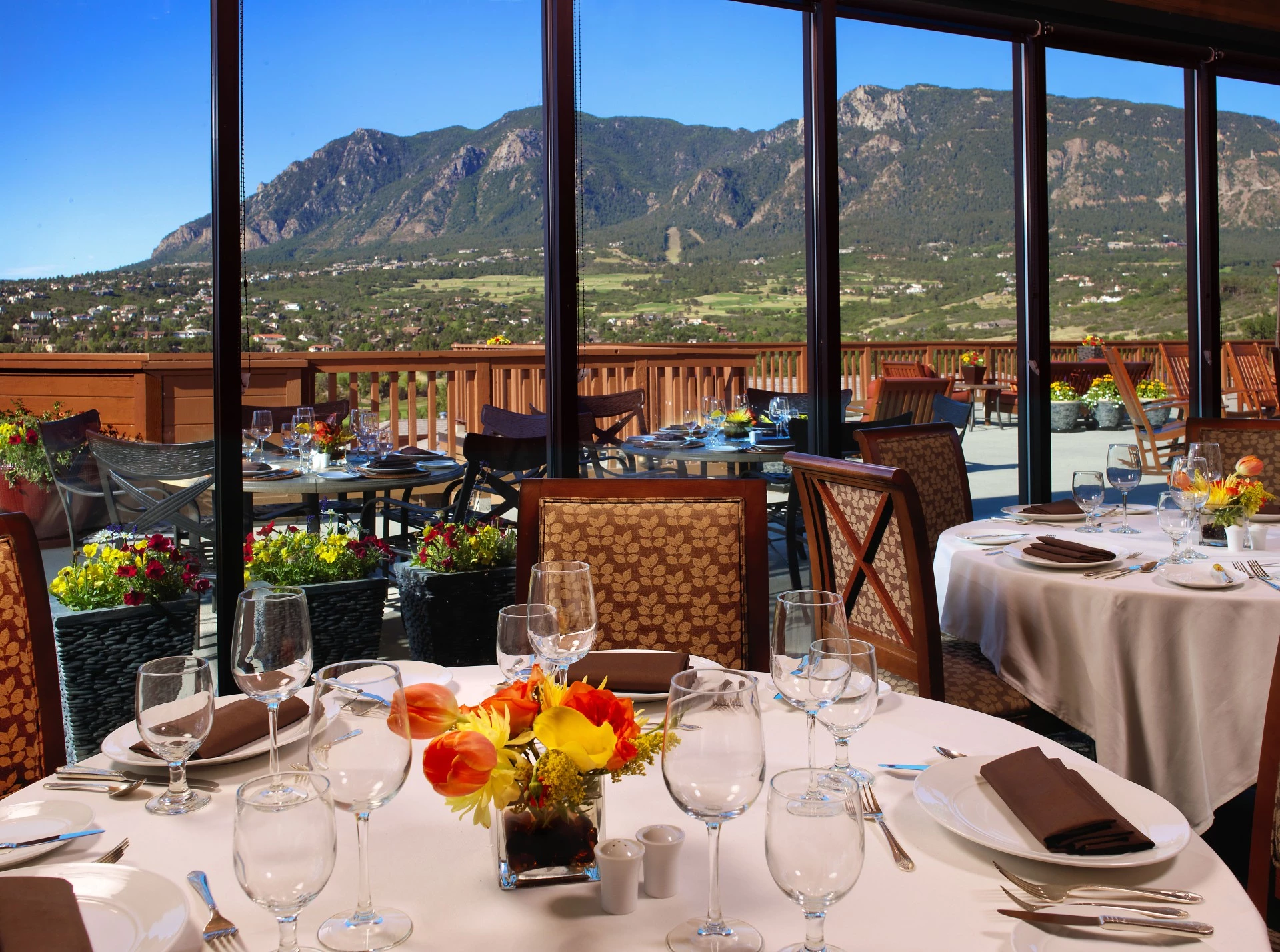 a table set for a dinner with a view of mountains and a valley
