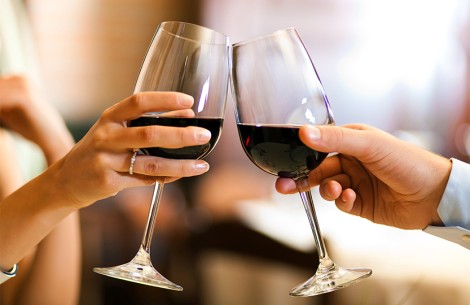 a pair of hands holding wine glasses