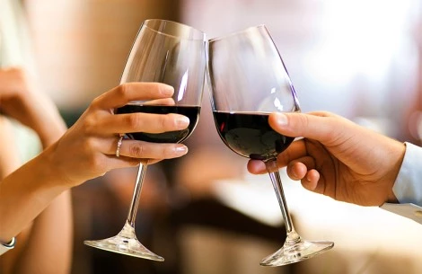 a pair of hands holding wine glasses