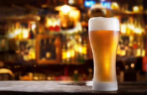 a glass of beer on a bar counter