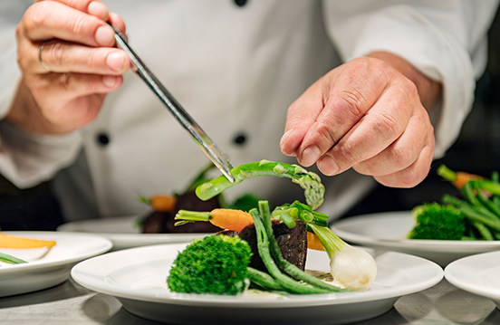 a chef preparing food on a plate