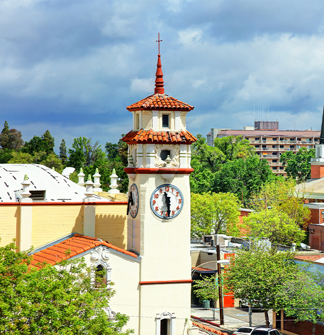 a clock tower with a cross on top of a building